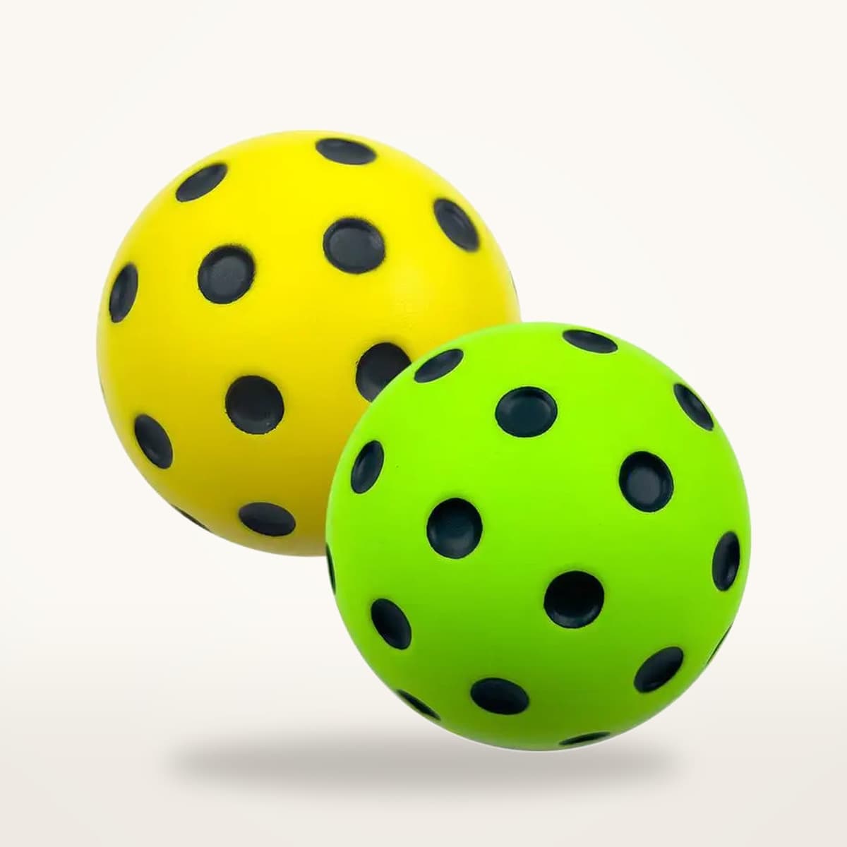 Deux balles de pickleball silencieuses, une jaune et une verte, vues de trois quarts sur fond neutre