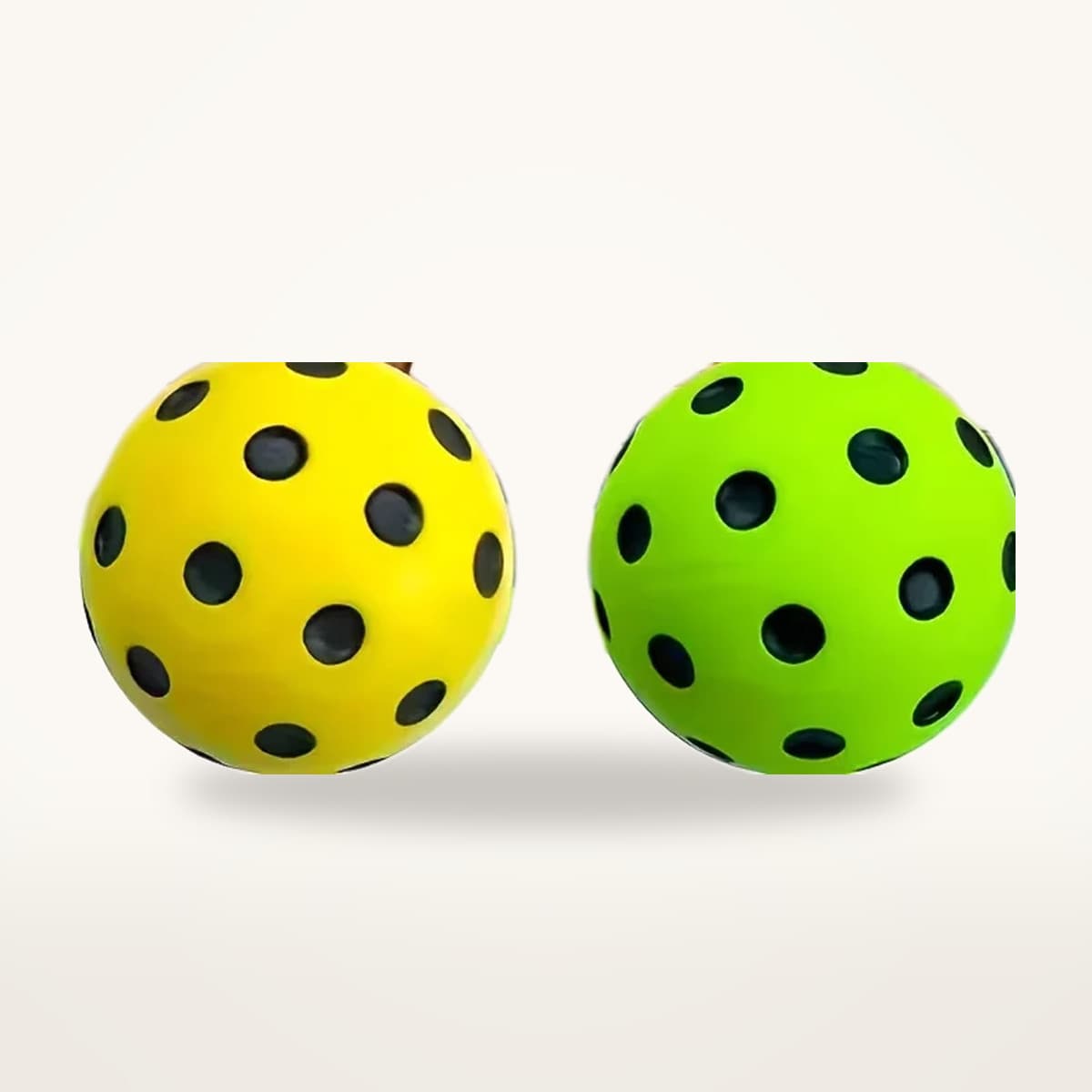 Deux balles de pickleball silencieuses, une jaune et une verte, posées côte à côte sur fond neutre