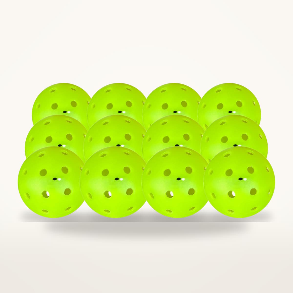 Douze balles de pickleball d'extérieur vert fluo percées de petits trous, alignées en trois rangées