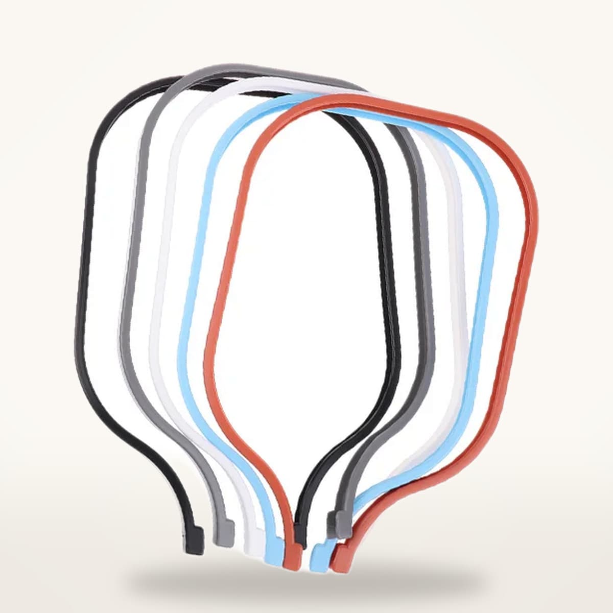 Cinq protections de tranche préformées, noire, grise, blanche, bleue et rouge, posées à plat